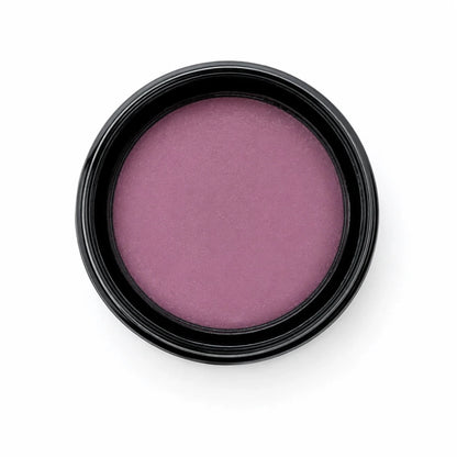 A single round makeup pan containing a shimmery mauve-purple cream product, set in a black plastic container against a solid white background.